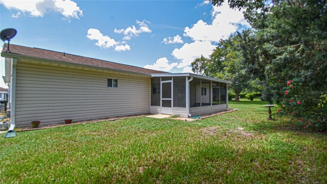 rear view of property with a sunroom and a yard