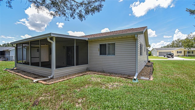 rear view of property with a sunroom and a yard