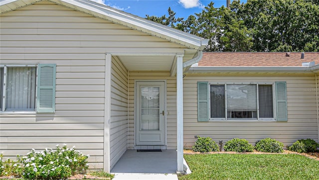 doorway to property featuring a lawn