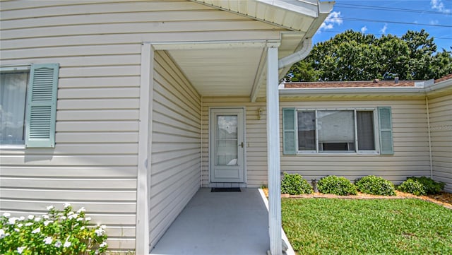 property entrance with a lawn