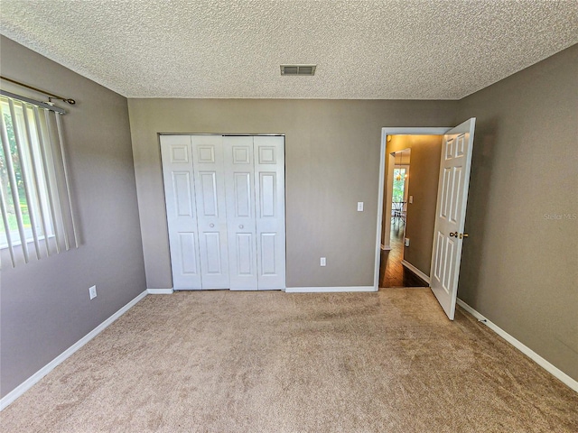 unfurnished bedroom featuring carpet, a closet, and a textured ceiling