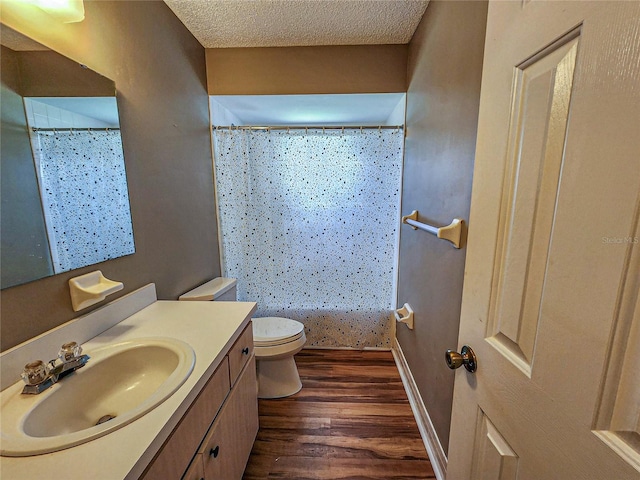 bathroom featuring vanity, a textured ceiling, hardwood / wood-style flooring, and toilet