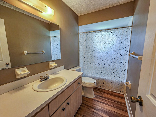 bathroom featuring vanity, a textured ceiling, hardwood / wood-style flooring, and toilet