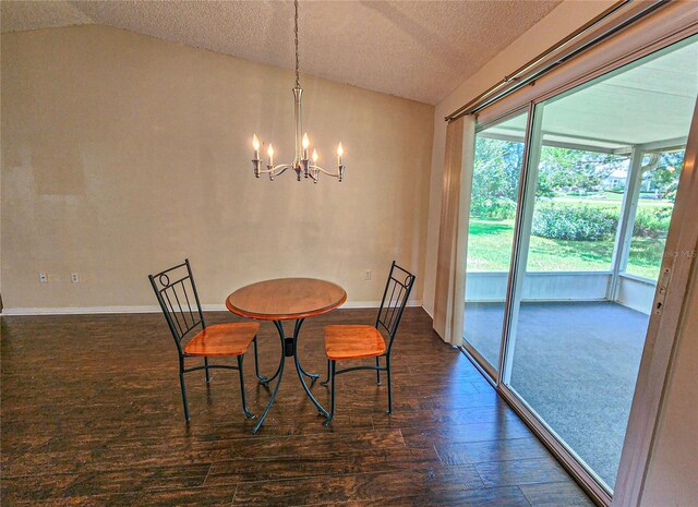 dining space featuring vaulted ceiling, a chandelier, plenty of natural light, and dark wood-type flooring