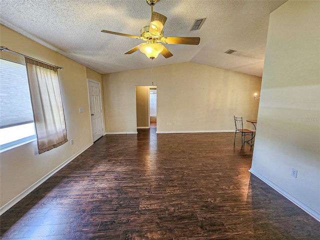 empty room featuring a textured ceiling, vaulted ceiling, hardwood / wood-style floors, and ceiling fan