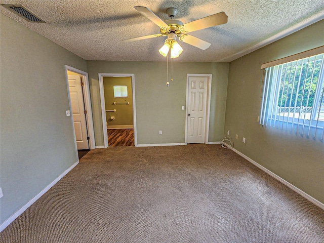 unfurnished bedroom with a textured ceiling, carpet floors, and ceiling fan