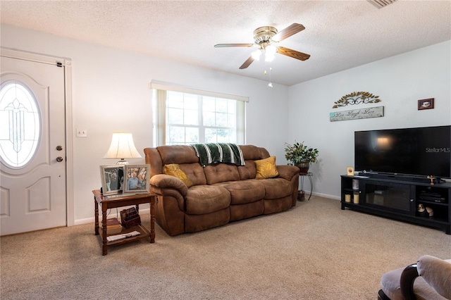 carpeted living room with a textured ceiling and ceiling fan