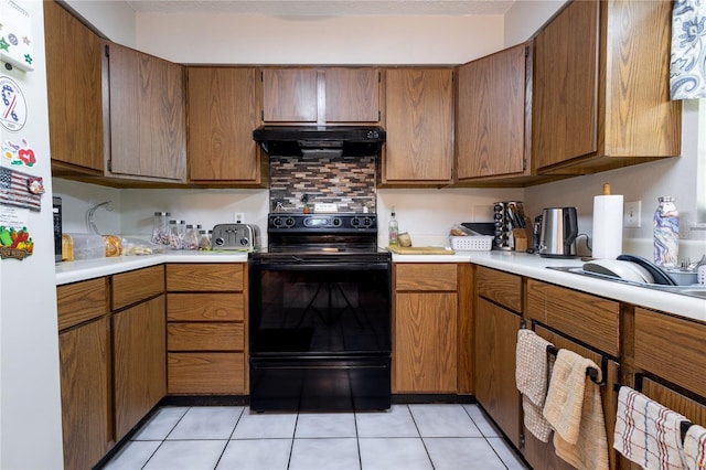 kitchen with black electric range, extractor fan, white refrigerator, and light tile patterned floors