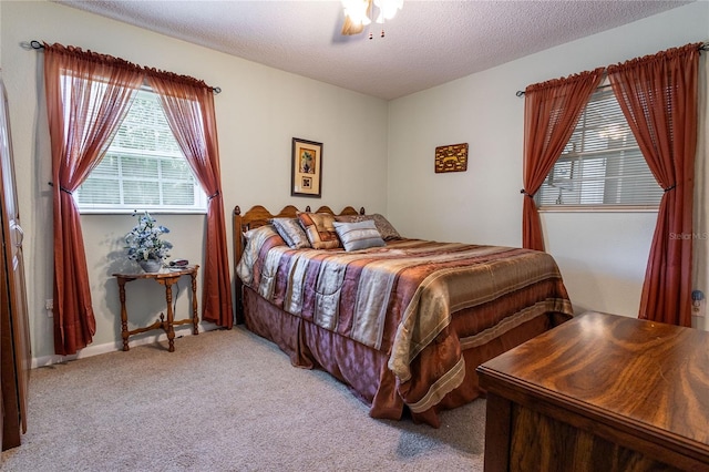 carpeted bedroom with a textured ceiling and ceiling fan