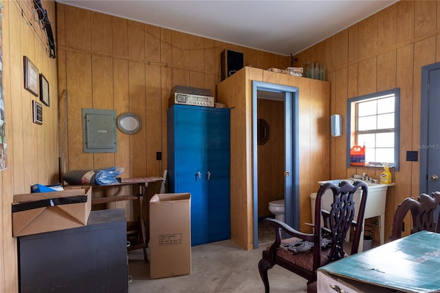 home office featuring electric panel and wooden walls