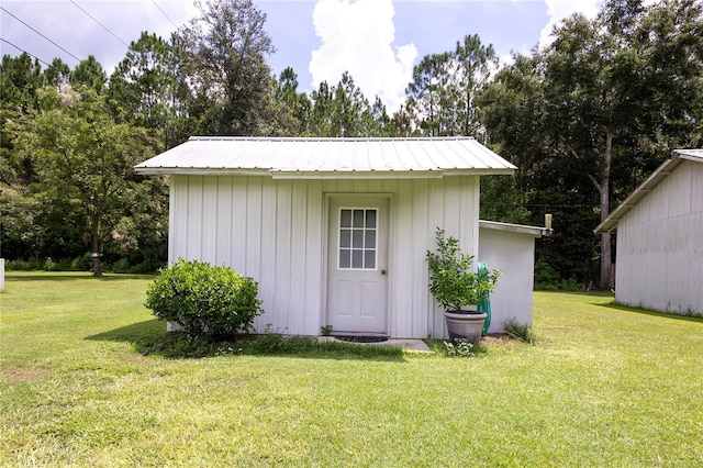 view of outbuilding featuring a lawn