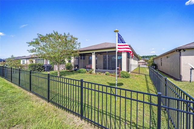 rear view of property featuring a lawn and a fenced backyard