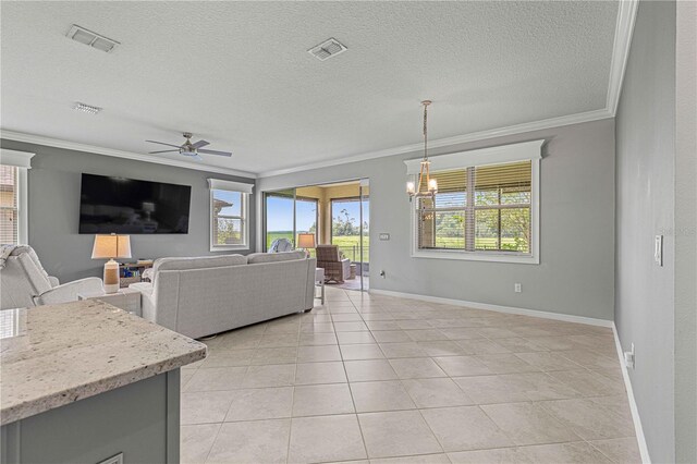 living room with plenty of natural light, ceiling fan with notable chandelier, visible vents, and ornamental molding