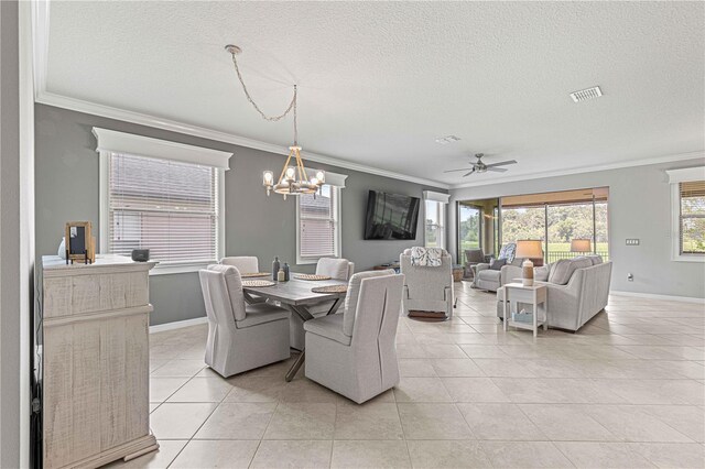 tiled dining area with ceiling fan with notable chandelier, a textured ceiling, and ornamental molding