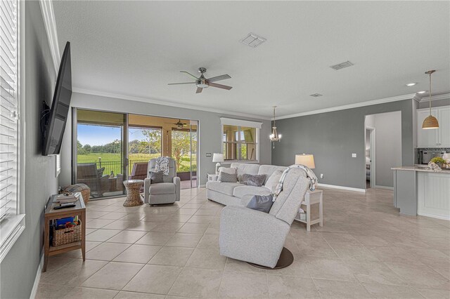 tiled living room featuring ceiling fan with notable chandelier and crown molding