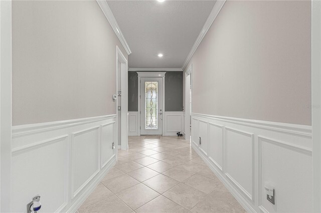 doorway to outside featuring light tile patterned floors, crown molding, and a textured ceiling