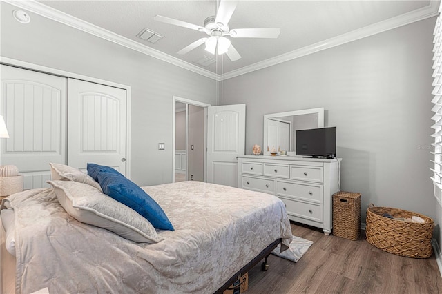 bedroom with crown molding, hardwood / wood-style flooring, ceiling fan, and a closet