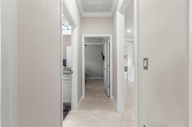 corridor featuring light tile patterned floors, visible vents, crown molding, and a textured wall