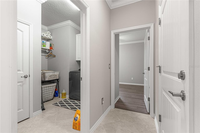 washroom with light tile patterned floors, cabinet space, a textured ceiling, and ornamental molding