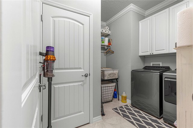 clothes washing area with a textured ceiling, cabinets, ornamental molding, and independent washer and dryer