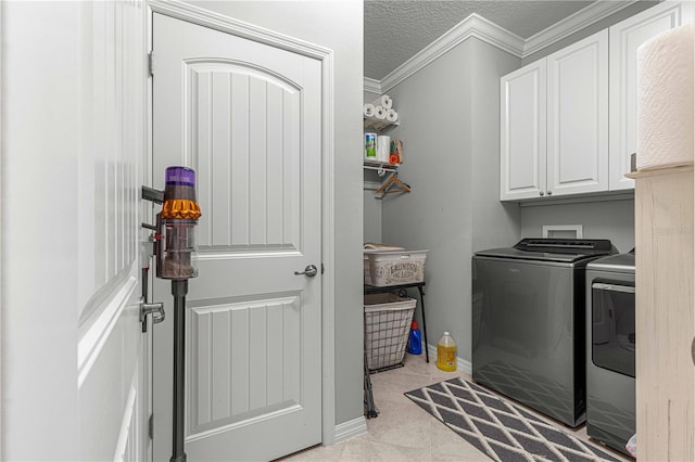 clothes washing area with independent washer and dryer, a textured ceiling, cabinet space, crown molding, and baseboards