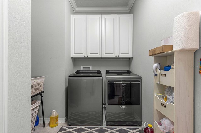 clothes washing area with light tile patterned floors, crown molding, cabinets, and independent washer and dryer