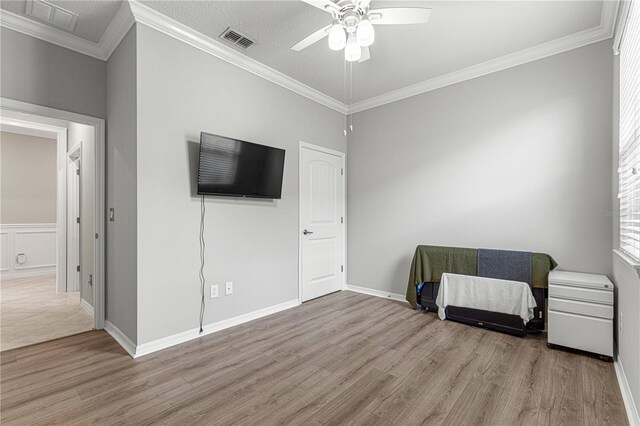 bedroom with crown molding, a textured ceiling, ceiling fan, and light hardwood / wood-style floors