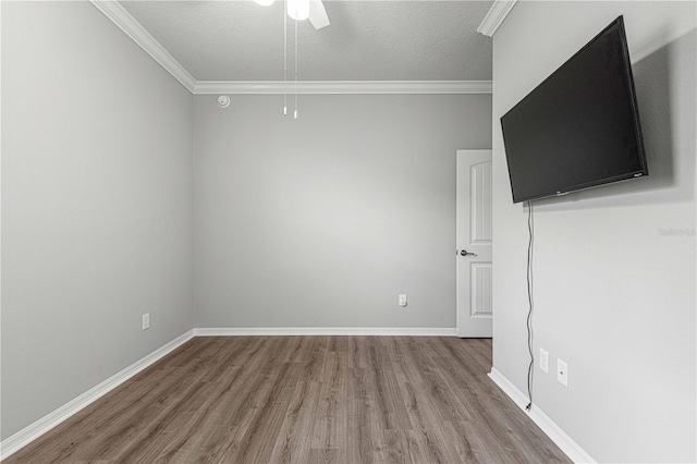 unfurnished room featuring ornamental molding, wood finished floors, baseboards, and ceiling fan