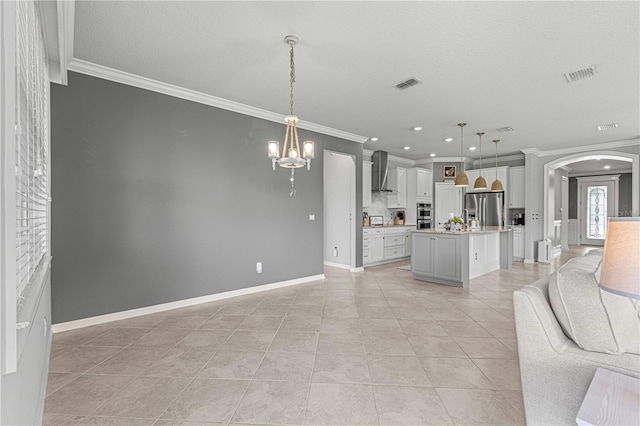 unfurnished living room featuring a textured ceiling, ornamental molding, light tile patterned floors, and a notable chandelier