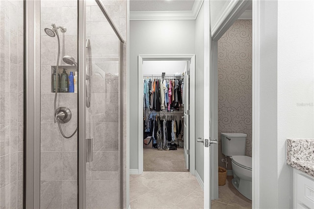 bathroom with a shower stall, a walk in closet, toilet, ornamental molding, and vanity
