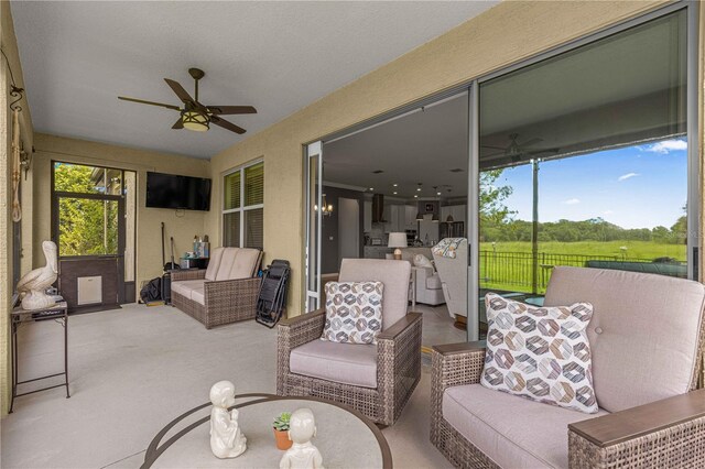 sunroom / solarium featuring ceiling fan