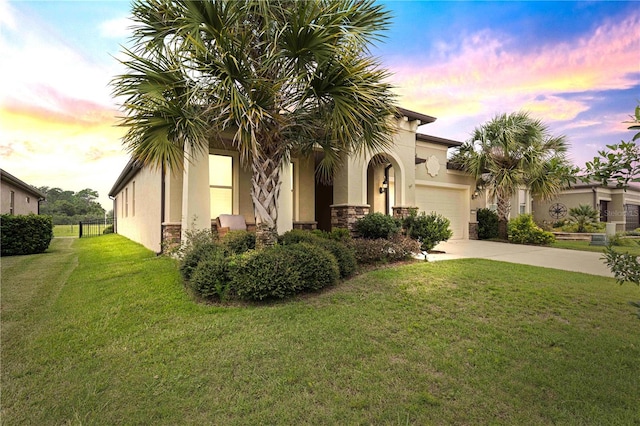 mediterranean / spanish-style house with a garage and a lawn