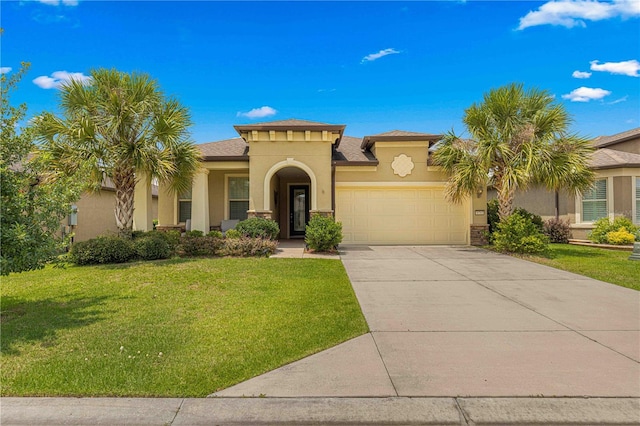 mediterranean / spanish home with a front yard, stucco siding, driveway, stone siding, and an attached garage
