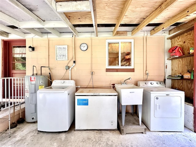 clothes washing area with washer and clothes dryer, water heater, and sink