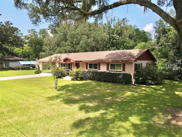 ranch-style home featuring a front yard, driveway, and a carport