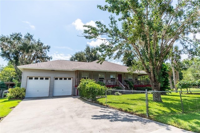 ranch-style house featuring a front lawn, covered porch, and a garage