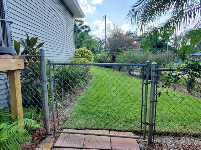 view of gate with a lawn