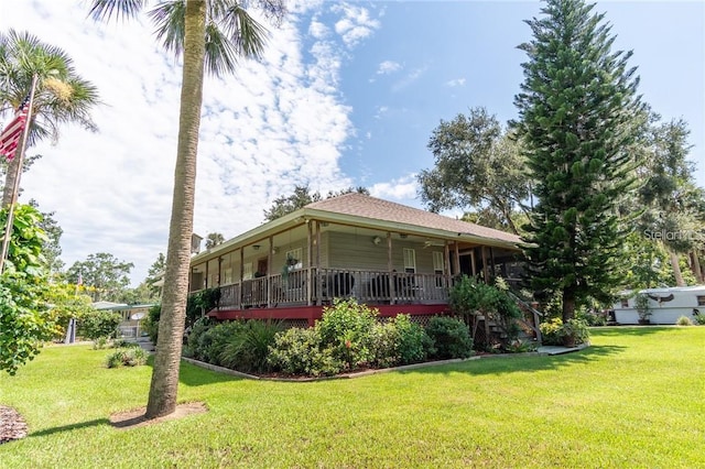 rear view of house with a wooden deck and a lawn