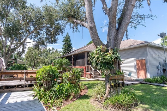 back of property featuring a wooden deck and a yard