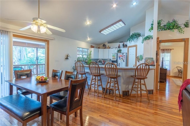 dining space featuring ceiling fan, light hardwood / wood-style flooring, and high vaulted ceiling