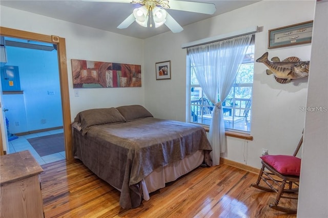 bedroom with ceiling fan, access to outside, and light hardwood / wood-style floors