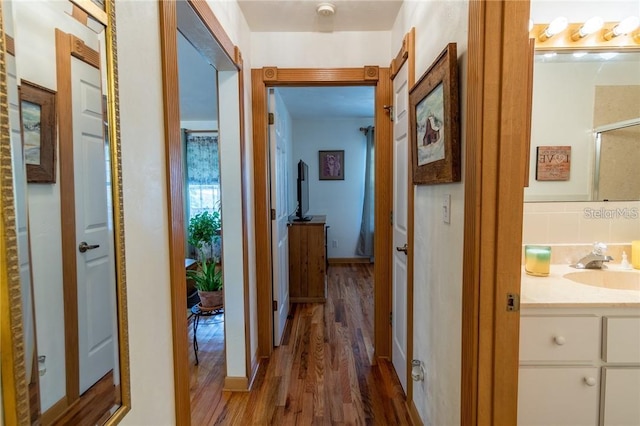 hallway featuring hardwood / wood-style floors and sink