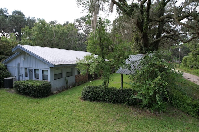 exterior space featuring metal roof and a yard