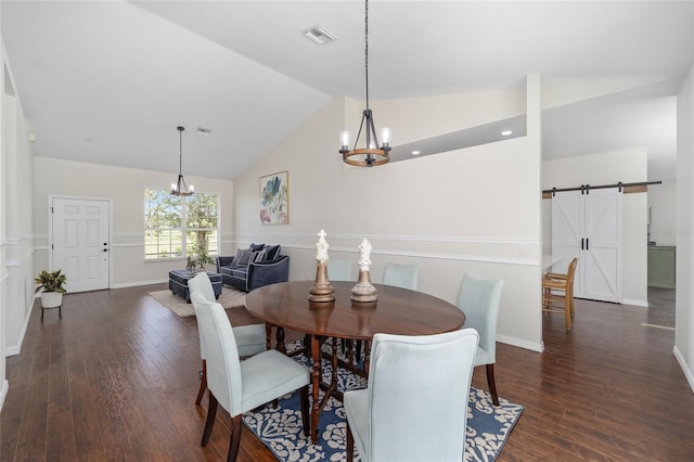 dining space with a chandelier, lofted ceiling, a barn door, and dark hardwood / wood-style floors