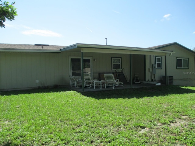 rear view of house featuring a yard