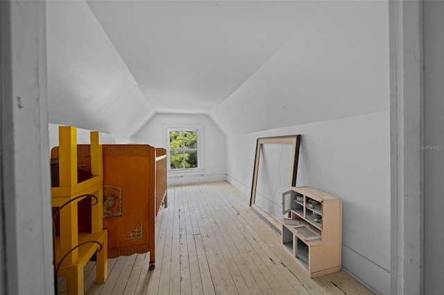 additional living space with light wood-type flooring and lofted ceiling