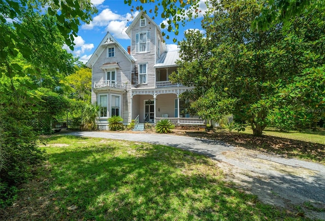 victorian home featuring a front lawn and covered porch