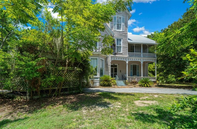 view of front of home with covered porch and a front lawn