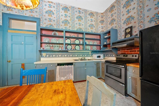 kitchen featuring light tile patterned flooring, wall chimney range hood, stainless steel range with electric stovetop, dishwasher, and black fridge