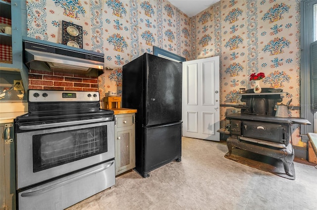 kitchen featuring electric range, wood counters, black refrigerator, and light tile patterned floors